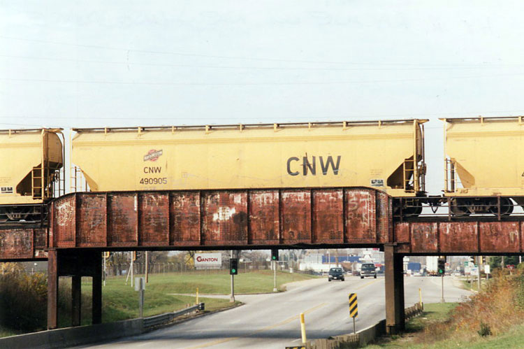 015.jpg.jpg - Another C&NW Hopper crossing over Highway 11 on the New Line in October 2005.  It’s faded but you can still see the C&NW logo